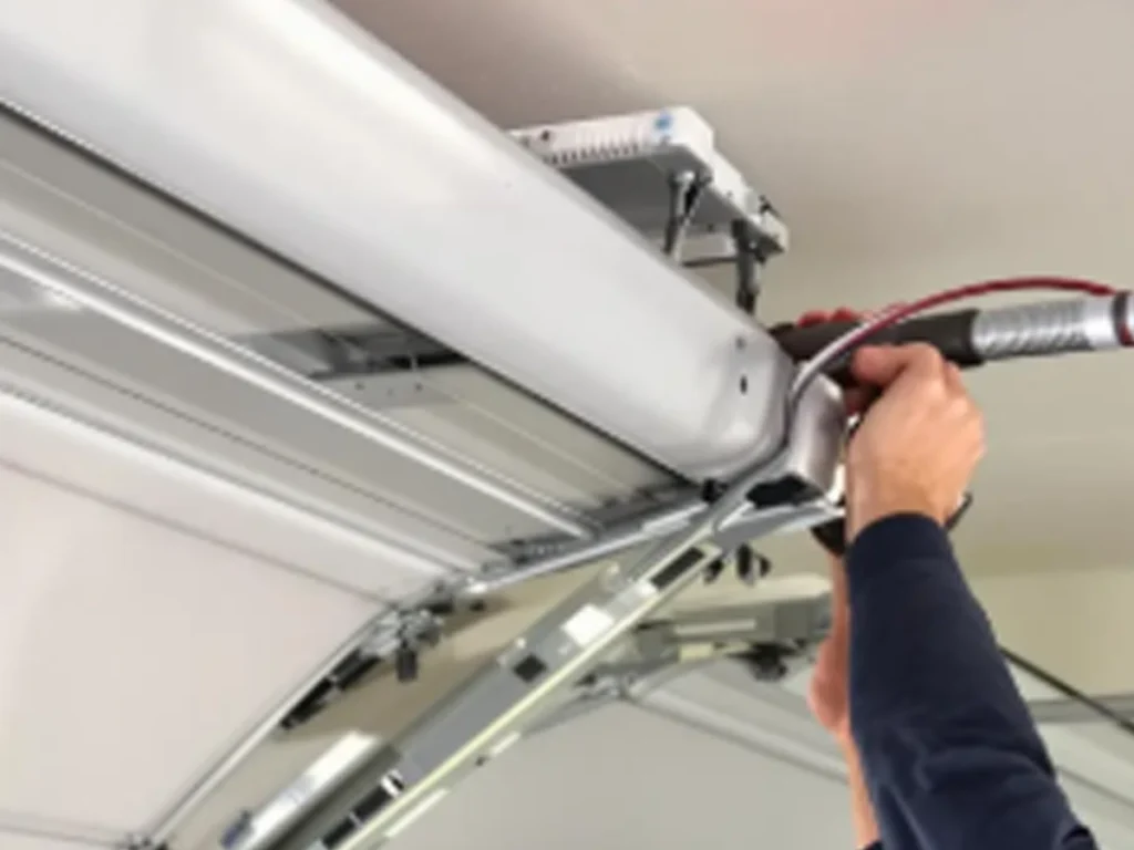 Garage door parts replacement Franklin technician inspecting springs and rollers