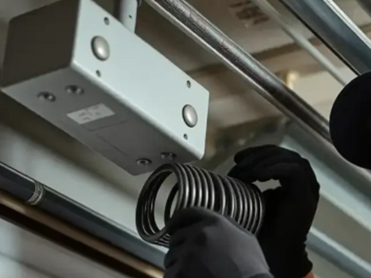 Garage repair technician fixing door in Franklin using simple preventive maintenance