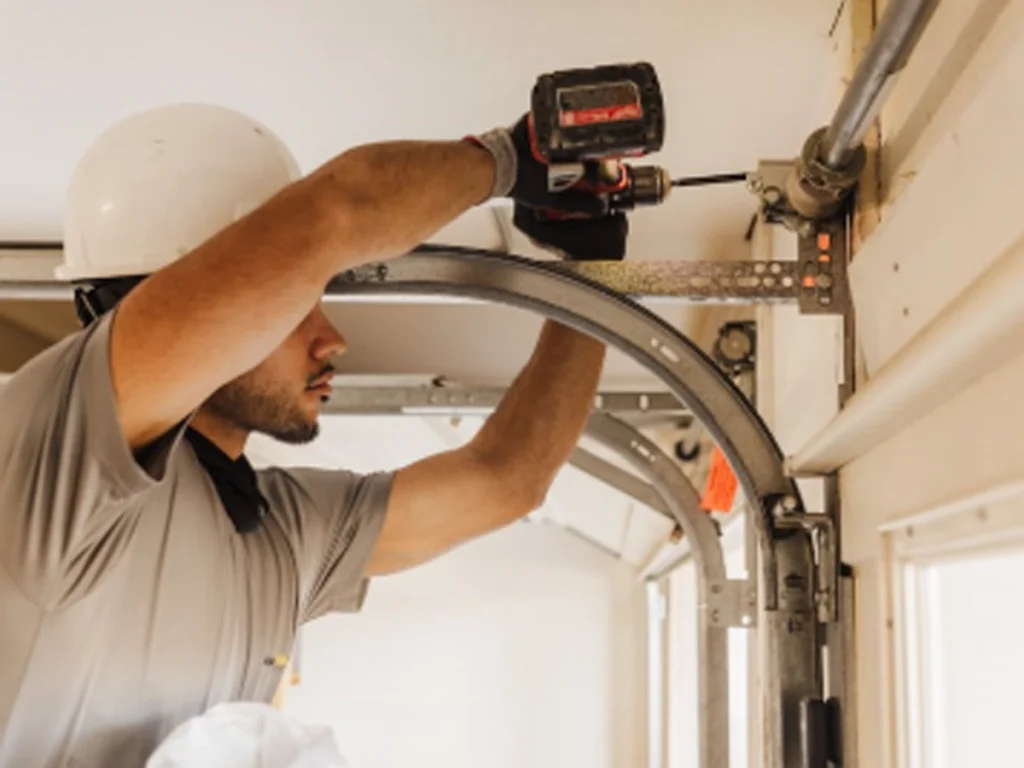 nnual garage door maintenance technician inspecting door rollers and safety sensors in Franklin TN