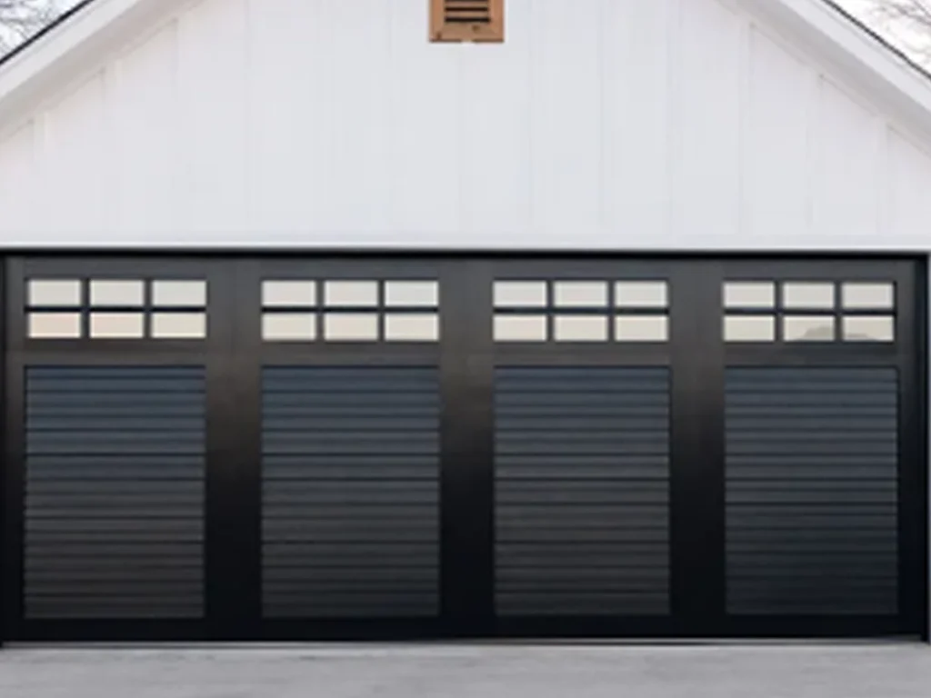 Modern custom garage doors with classic recessed panels, arched windows, and dark hardware on a refined Franklin, Tennessee home