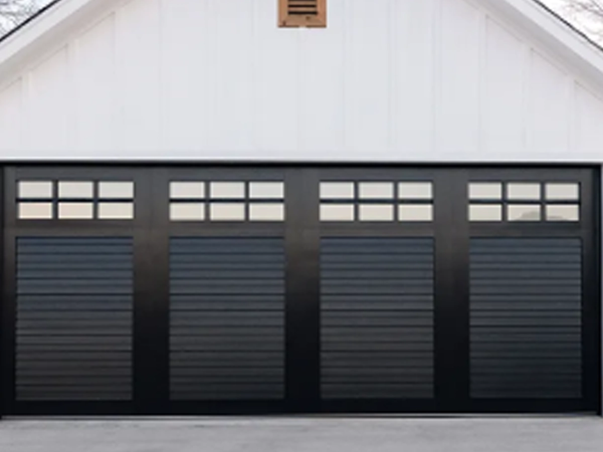 Modern custom garage doors with classic recessed panels, arched windows, and dark hardware on a refined Franklin, Tennessee home
