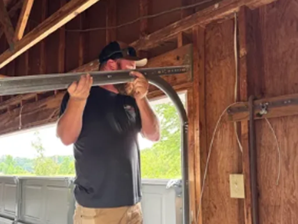 Residential garage door repair technician inspecting an aging door system in Franklin, Tennessee