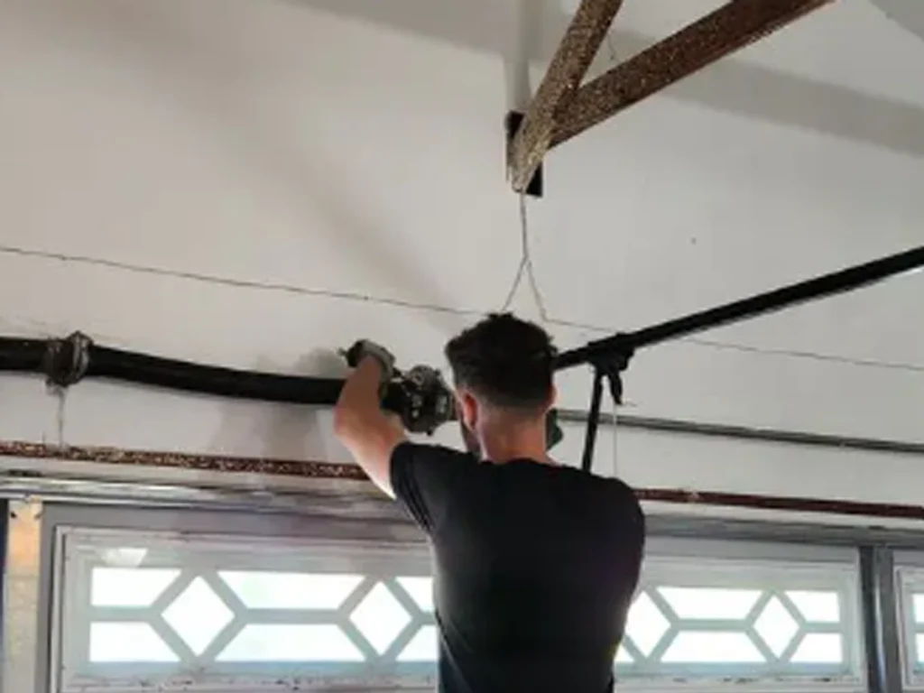 Signs your garage door parts are wearing out, including frayed cables, worn rollers, loose hinges, and a damaged spring